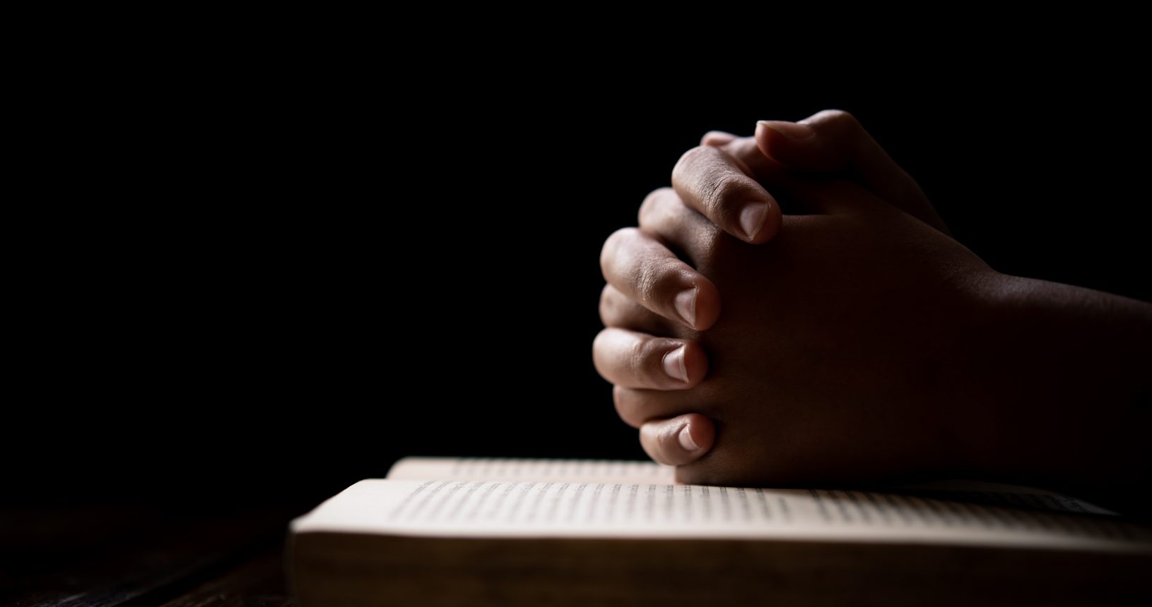 hands woman laying on the biblical while praying for christian religion blessings and Pray to God onnuree
